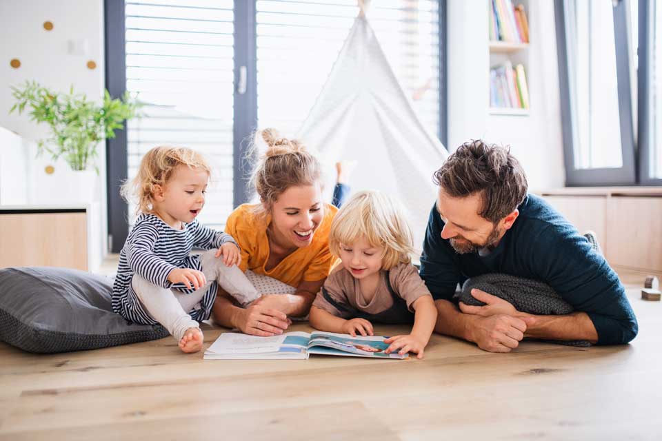 family spending time on floor reading book